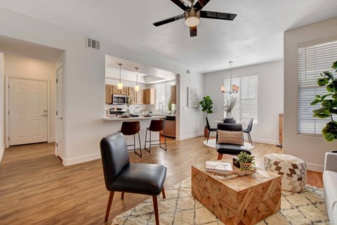 A living room with a black leather chair and a wooden coffee table.