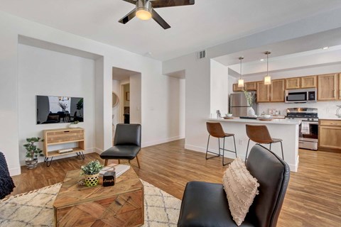 A modern living room with a wooden coffee table and a black leather chair.