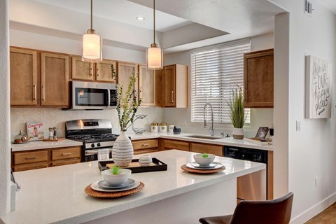 A modern kitchen with a white countertop and wooden cabinets.