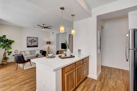 A modern kitchen with wooden floors and a white island.
