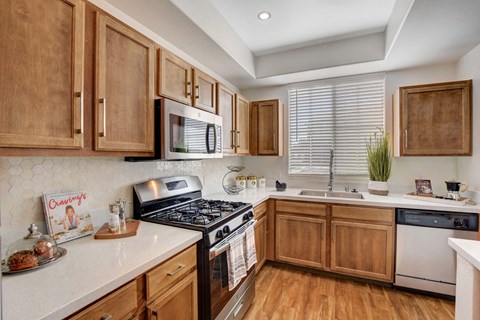 A kitchen with wooden cabinets and a black stove top.