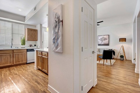 A kitchen with wooden floors and a white door.