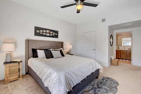 A bedroom with a large bed and a ceiling fan.
