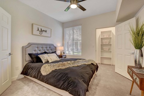 A bedroom with a large bed and a ceiling fan.