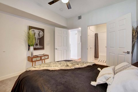A bedroom with a large bed and a painting of an elephant on the wall.