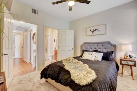 A bedroom with a large bed and a ceiling fan.