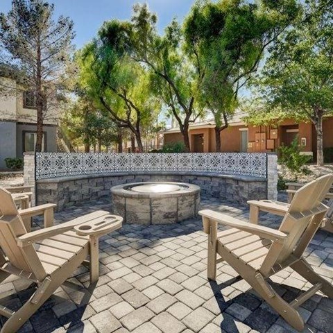 A hot tub sits in the middle of a patio with two chairs on either side.