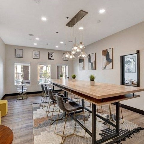 A modern dining room with a long wooden table and chairs.