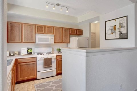 A kitchen with wooden cabinets and white appliances.