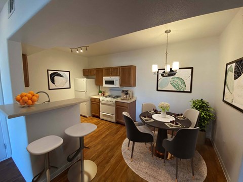 A kitchen with a dining table and chairs.