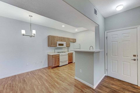 A kitchen with wooden floors and white walls.