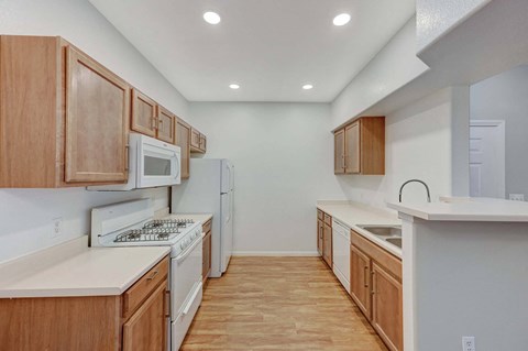 A kitchen with wooden cabinets and white appliances.