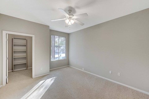 A room with a ceiling fan and a window.
