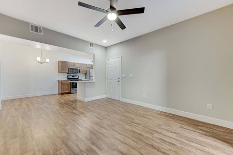 A room with a ceiling fan and wooden flooring.