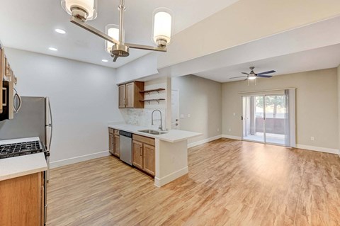 A kitchen with wooden floors and a ceiling fan.