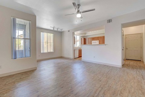 A spacious room with wooden floors and a ceiling fan.