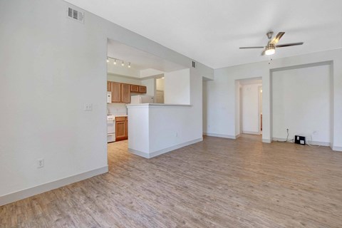 A room with a ceiling fan and wooden flooring.