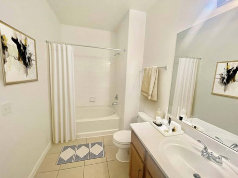 A bathroom with a white tub, sink, and toilet.