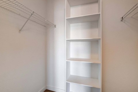 A white shelving unit in a room with white walls.