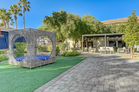 A backyard with a swing set and a patio.