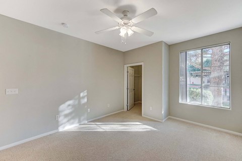 A room with a ceiling fan and a window.
