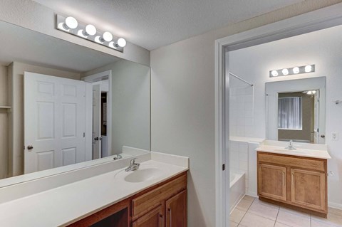 A bathroom with a white counter top and a white sink.