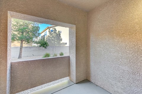 A room with a window showing a tree and a building outside.
