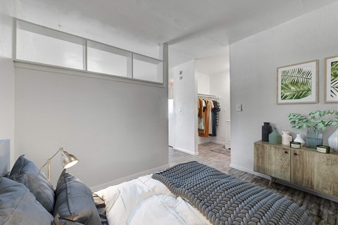 A bedroom with a bed, pillows, a lamp, and a wooden cabinet.