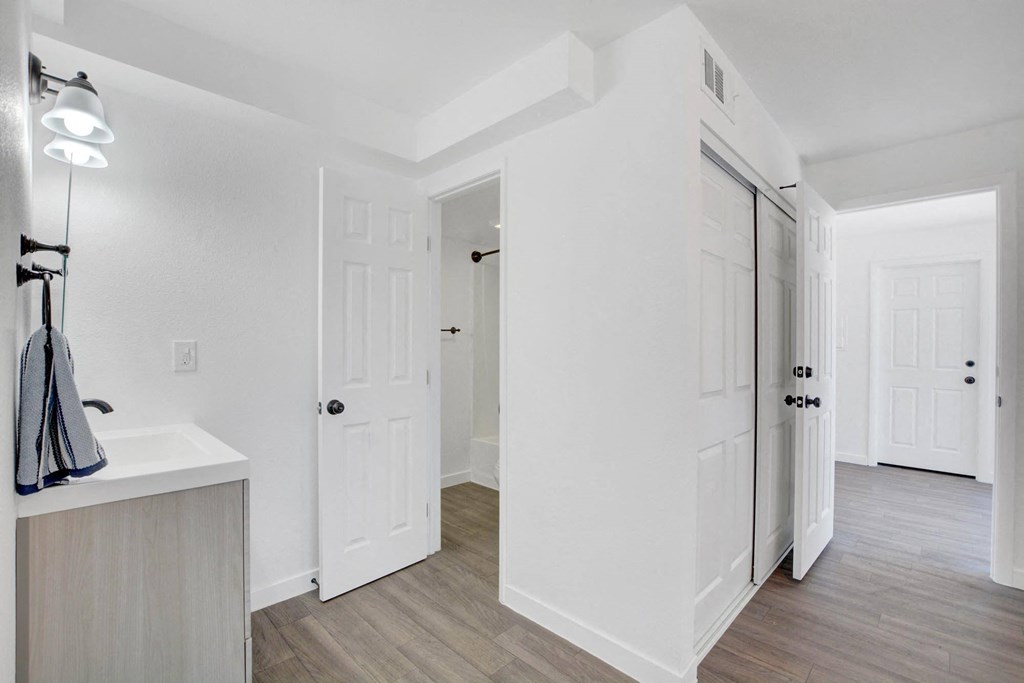 A white bathroom with a sink and a light on.
