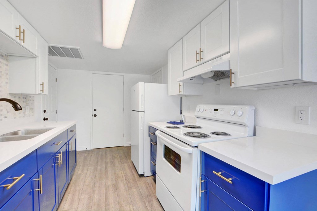 A kitchen with white cabinets and blue drawers.