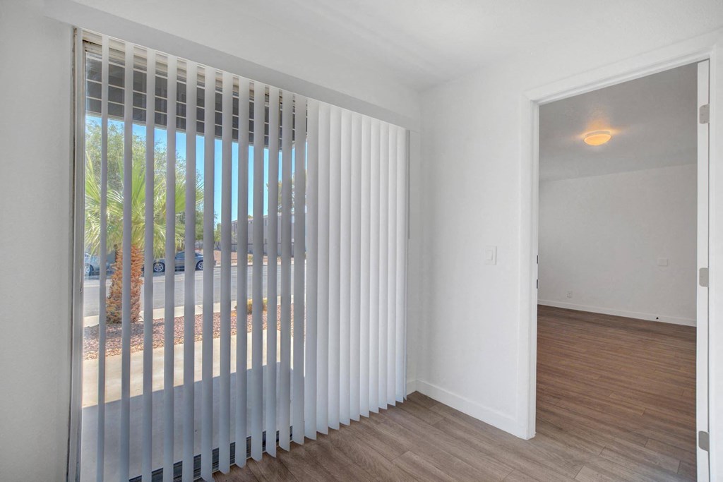 A room with a sliding door and a window with blinds.