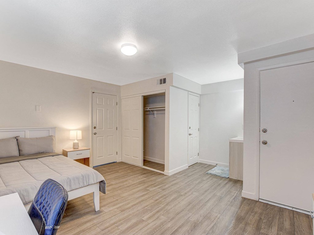 A bedroom with a bed, chair, and wardrobe.