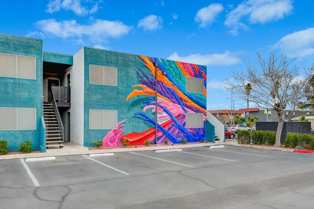 A colorful mural of a flamingo is painted on the side of a building.