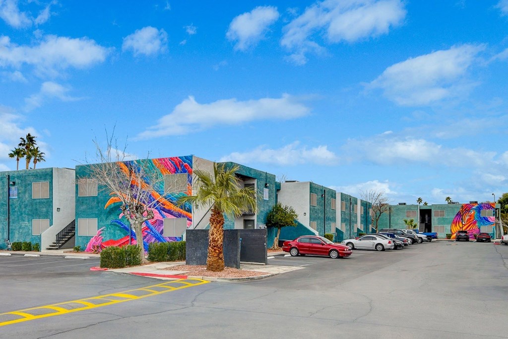 A wall with a colorful mural of a palm tree and a bird.