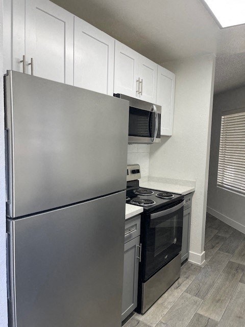 A modern kitchen with a stainless steel refrigerator and oven.