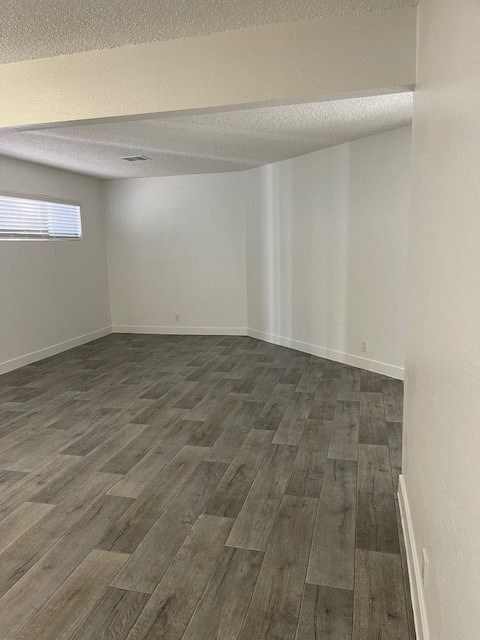 A room with wooden flooring and white walls.