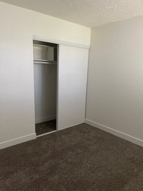A room with a carpeted floor and a white door.
