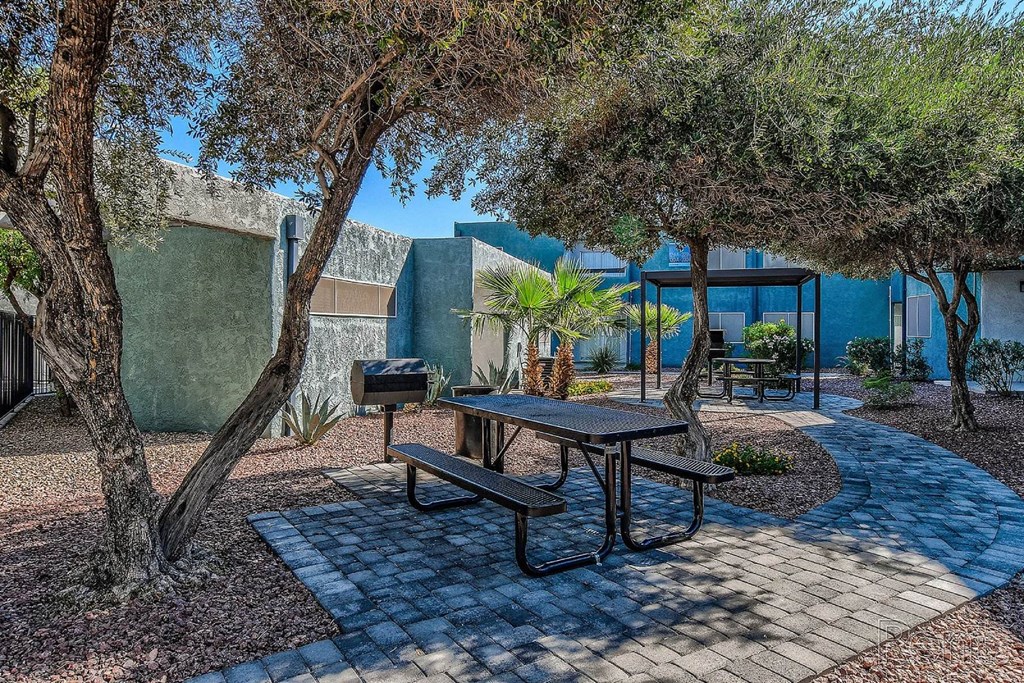 A picnic table is surrounded by trees in a courtyard.