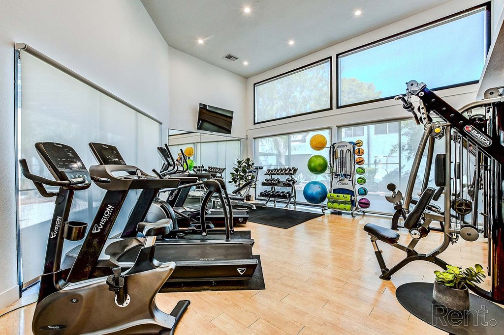 A gym with treadmills, exercise bikes, and weights.