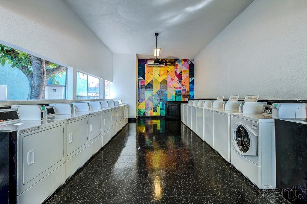 A laundromat with a row of washers and dryers.