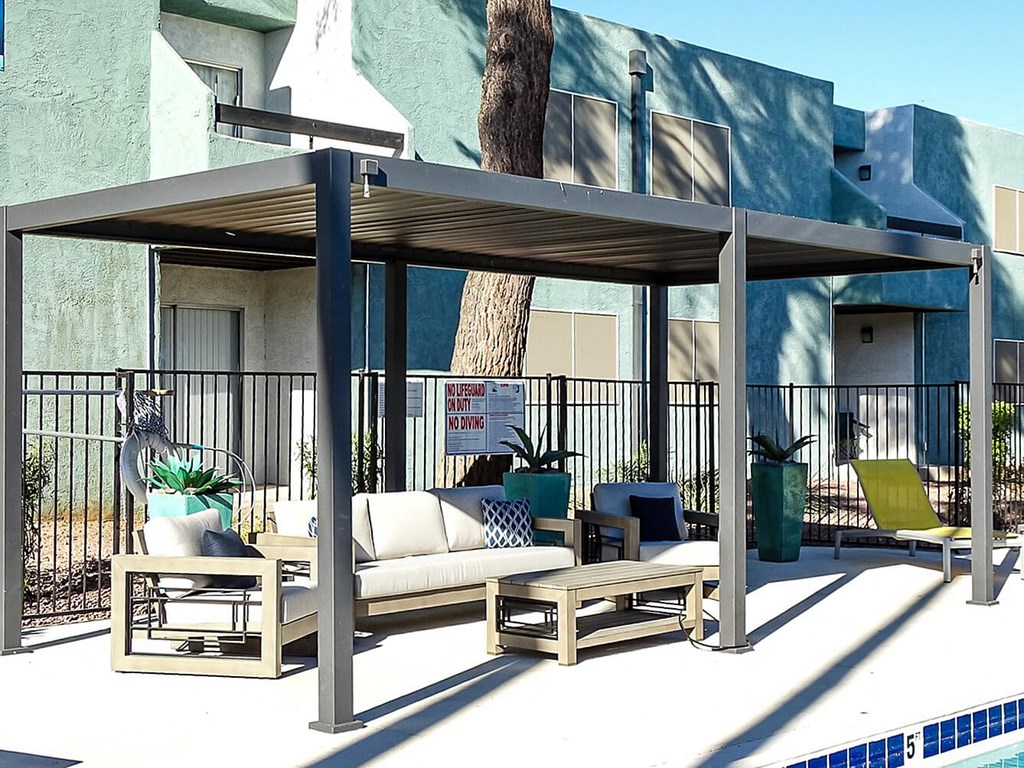 A poolside lounge area with a canopy and seating.