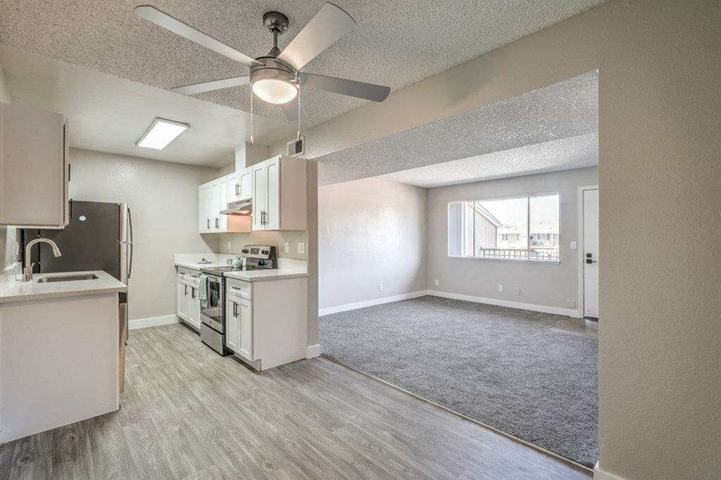 A kitchen with a fan and a dining table.