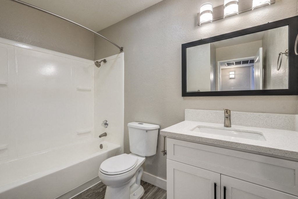 A white toilet sits next to a sink in a bathroom.
