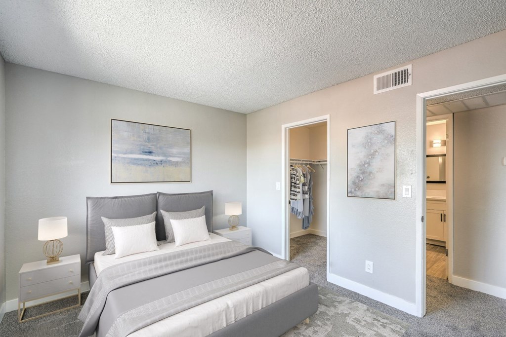 A bedroom with a large bed and a painting on the wall.