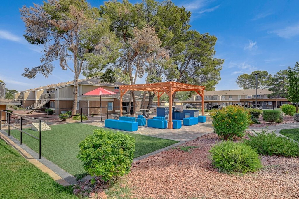 A playground area with a red swing set and blue play equipment.