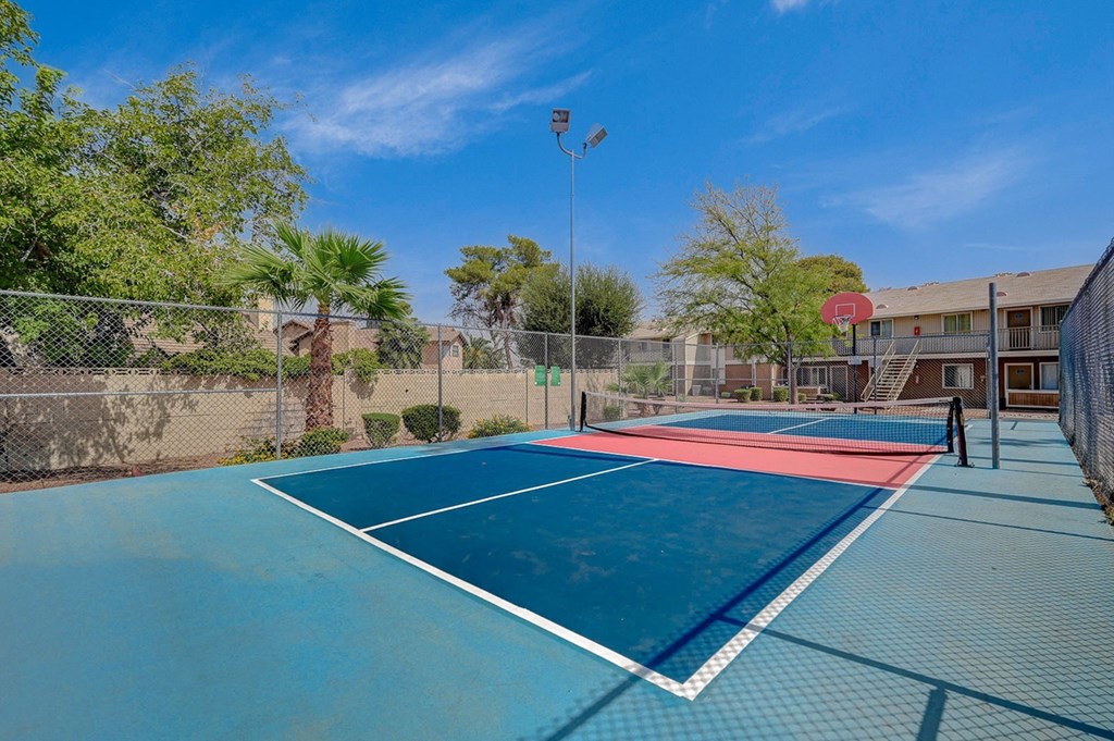 A tennis court with a red and white line in the middle.