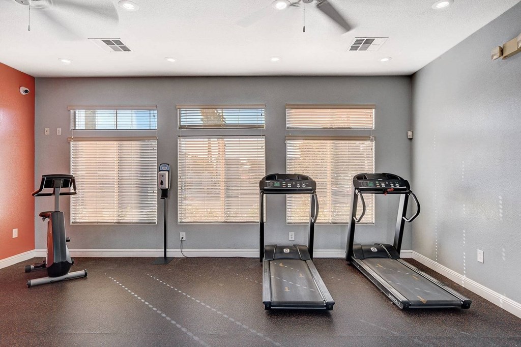 A room with treadmills and a fan.