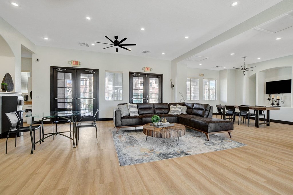 A living room with a black leather couch and a coffee table.