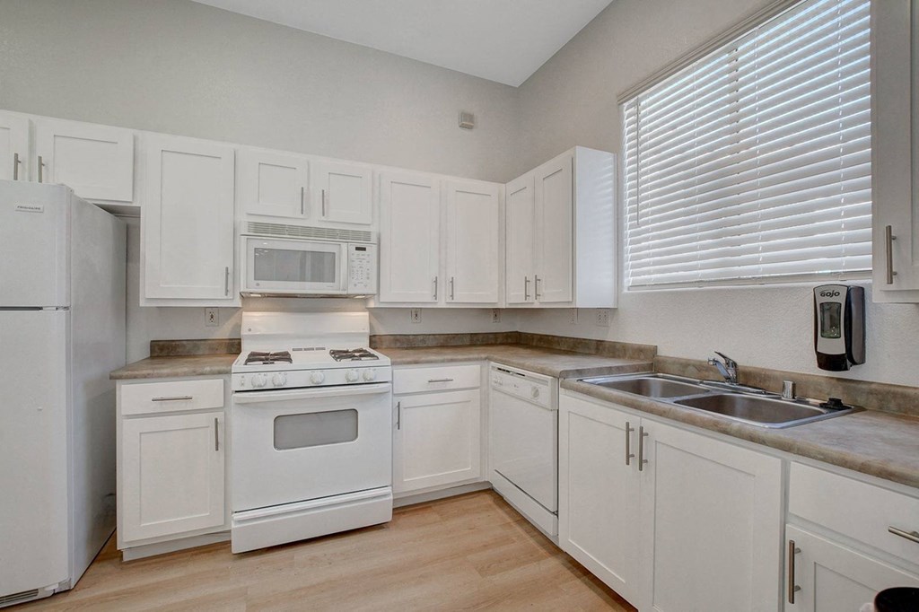 A kitchen with white appliances and cabinets.