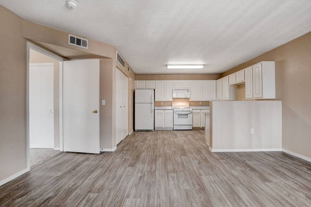 A kitchen with white cabinets and a white fridge.